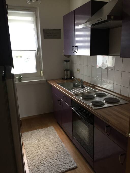 Küchenzeile, gegenüber befindet sich der Kühlschrank und eine weitere Zeile