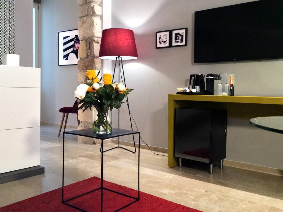 Questa suite estremamente esclusiva ha tra i suoi colori il grigio e il rosso porpora. L’ingresso ampio e comodo accoglie un divano letto matrimoniale e un armadio a vista disegnato e progettato su misura esclusivamente per CinqueSuites. Il letto ha un importante testata in pelle bianca capitonnè con a fianco le lampade String Light di Flos sospese a mezz’aria.
Una porta scorrevole in vetro satinato ci introduce nel bagno, spazioso e moderno, dai sanitari bianchi di alto design e una grande doccia dalla parete in marmette patchwork.
Dal bagno e dalla camera da letto si può accedere ad uno spazio esterno privato dove è collocata una comodissima e spaziosa vasca idromassaggio.