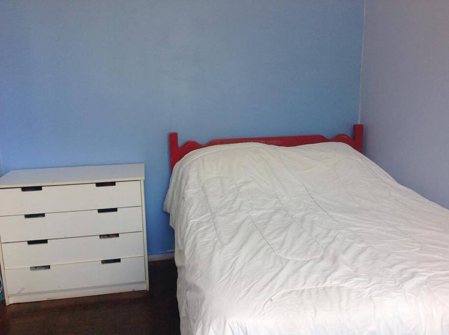 quarto com cômoda, mesa, ventilador e ar condicionado