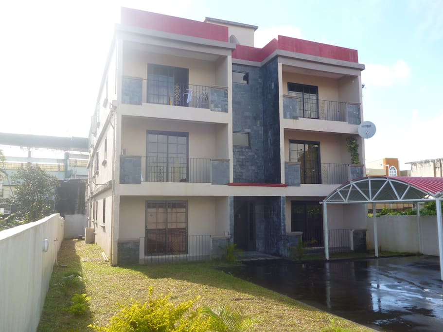 Outside of Residential Complex with garden and parking spaces