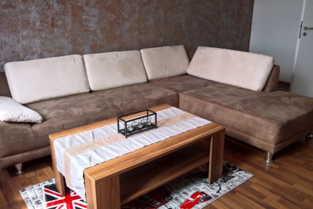 Wohnzimmer mit grosser Eckcouch, TV-Wand mit Flatscreen, Kratzbaum und
Hundekorb