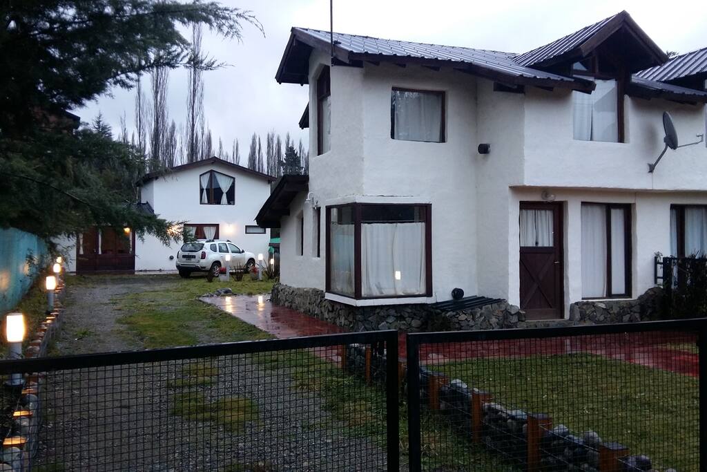 Son dos cabñas. La cabaña de adelante cuenta con dos dormitorios en la planta alta, uno matrimonial y el otro con dos camas individuales, tipo cucheta. Además tienen un sillón cama para una persona en el living. El equipamiento de la de adelante es para 5 personas. Cuenta con una cocina completa, baño con antebaño, living, calefacción, DirecTV, Wi Fi, se brinda ropa de blanco y toallas que se cambia cada 3 días. La parilla para hacer asado está ubicada atrás, en el quincho abierto, lugar para estacionar 4 autos interno. El patio está totalmente cerrado, y se comparte con la cabaña de atrás. La limpieza durante la estadía es opcional, y de requerirla se abona aparta. Se admiten mascotas, y el lugar es adecuado para ellas, ya que está totalmente cercado. Se brinda un desayuno seco de bienvenida.
UBICADA a 2 km del Parque Nacional Lago Puelo. Dirección: Callejón Cortada 275, Lago Puelo