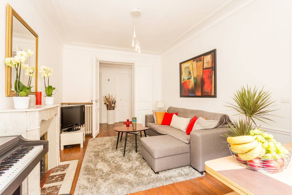 You will feel at home in this living room which includes a TV, fireplace and a piano.