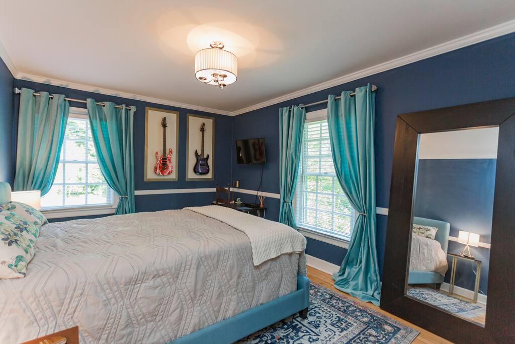2nd bedroom with queen bed, smart TV and electric guitars. I have an amp if you'd like to play them! The Ibanez needs to be re-strung but they're both playable/real guitars.