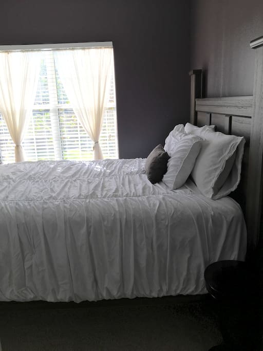 Purple guest bedroom: Queen-size bed can sleep two guests.
