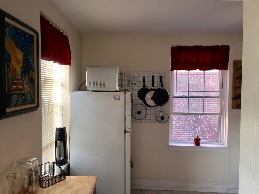 The kitchen accentuated by red saving counterspace by corkboard storage