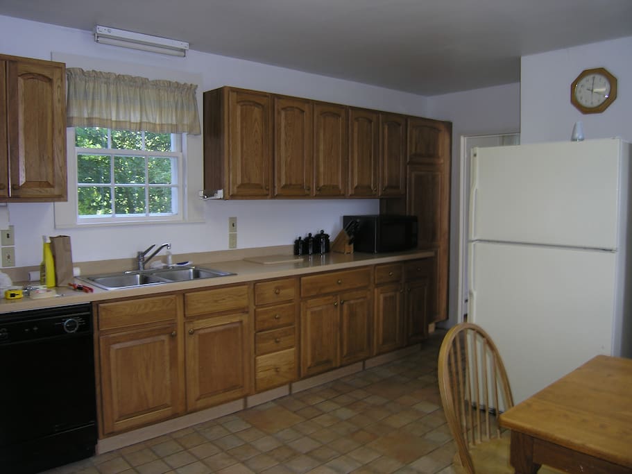 Wood-paneled kitchen with dishwasher, microwave, full stove, fully equipped