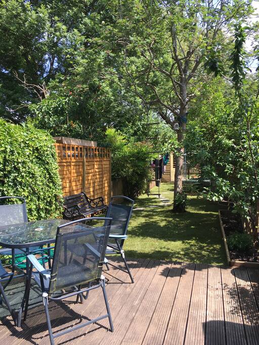 Bifold doors out to top decking and garden beyond with river decking at end of lawn