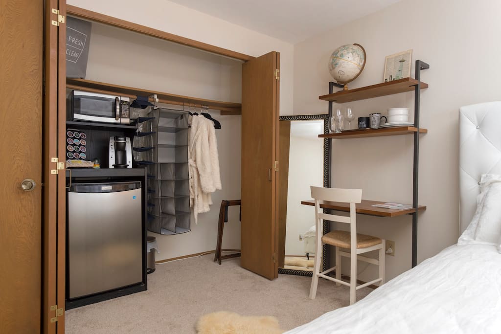 First bedroom - queen bed, desk, chair, mini fridge, Keurig coffee machine, microwave, cutlery, bowls, plates, luggage rack, full length mirror, hangers, alarm clock and soft guest bathrobes