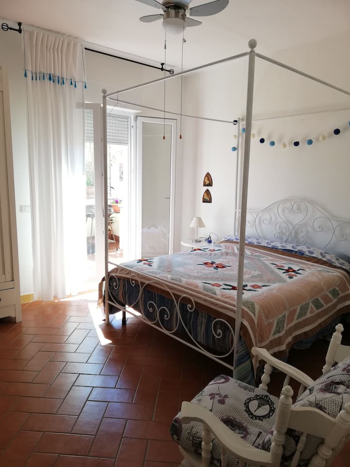 غرفة النوم الأولى بسرير مزدوج وباب تراس يمكن الوصول إليه مباشرة