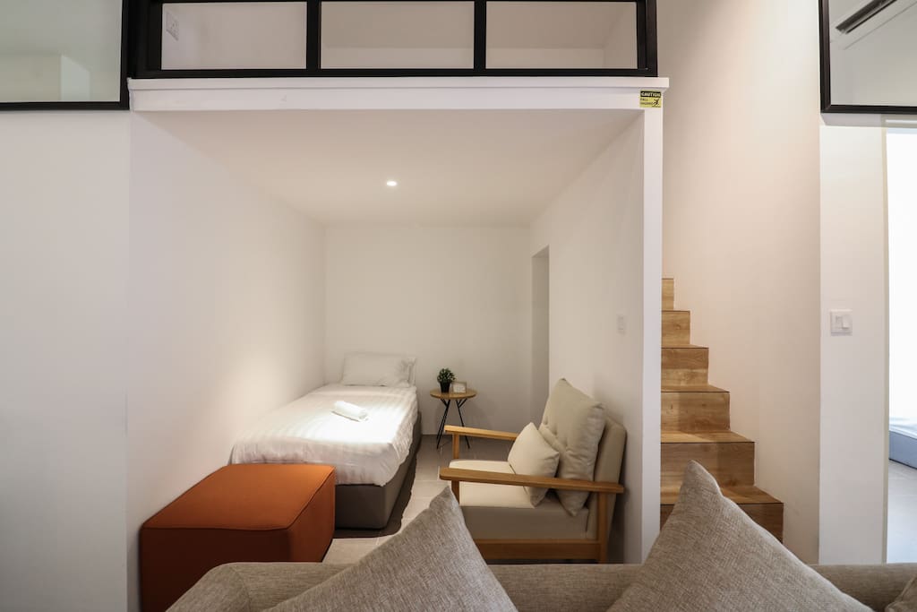 Single bed and relax area under loft