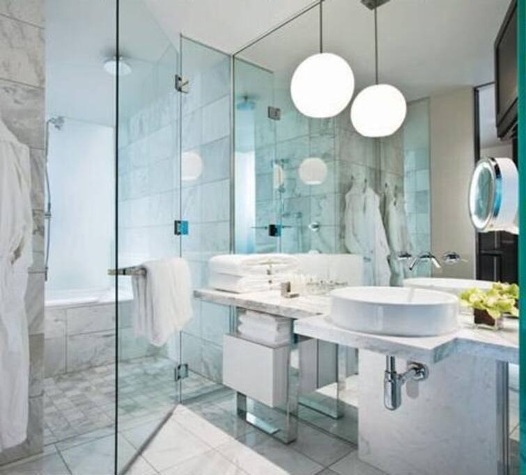 Marble Shower and Bath with Fresh Towels and Small TV