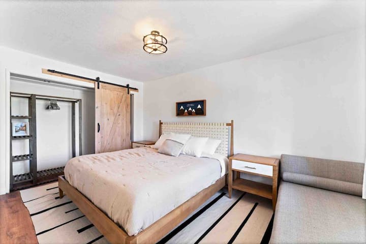 El dormitorio principal cuenta con un televisor inteligente LG de 65 pulgadas y un lujoso sofá cama que ofrece mucho espacio para descansar. 