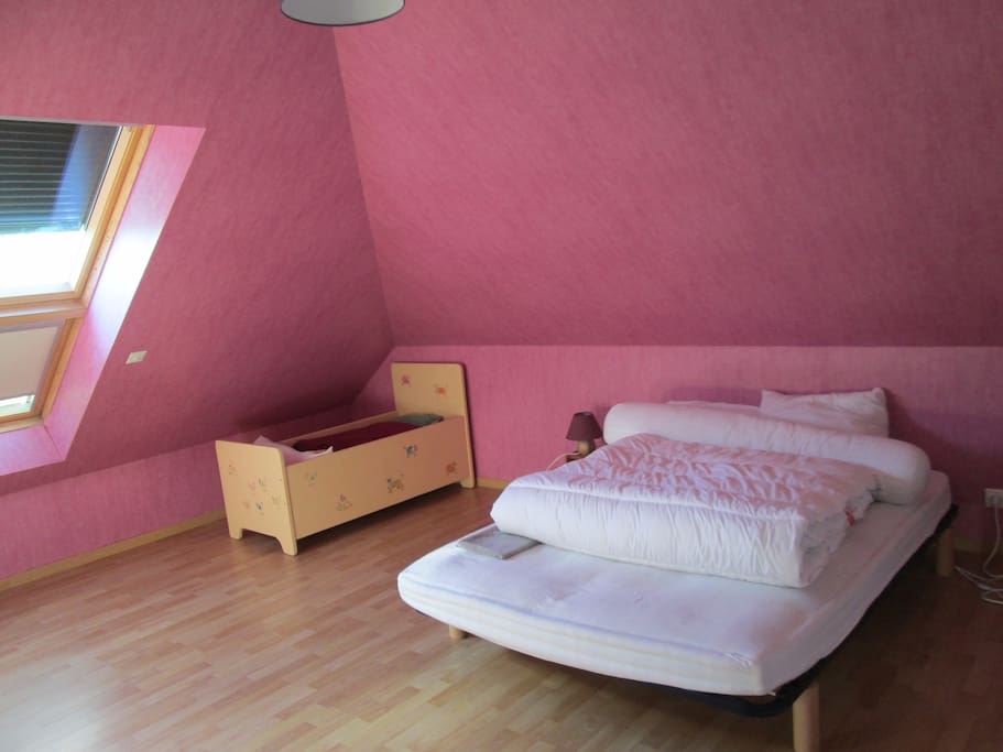 Chambre d'environ 25m² avec un lit double et un lit d'enfant/bébé, possibilité d'ajouter un lit simple supplémentaire.