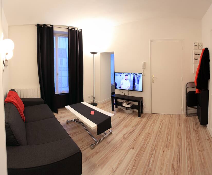 Salon vu depuis la porte de la chambre, on peut apercevoir l'accès à la cuisine, à gauche.