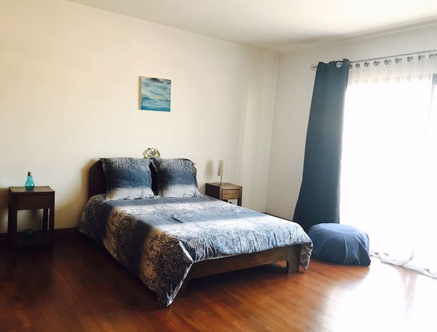 une chambre lumineuse avec un grand lit, dans des tons bleus