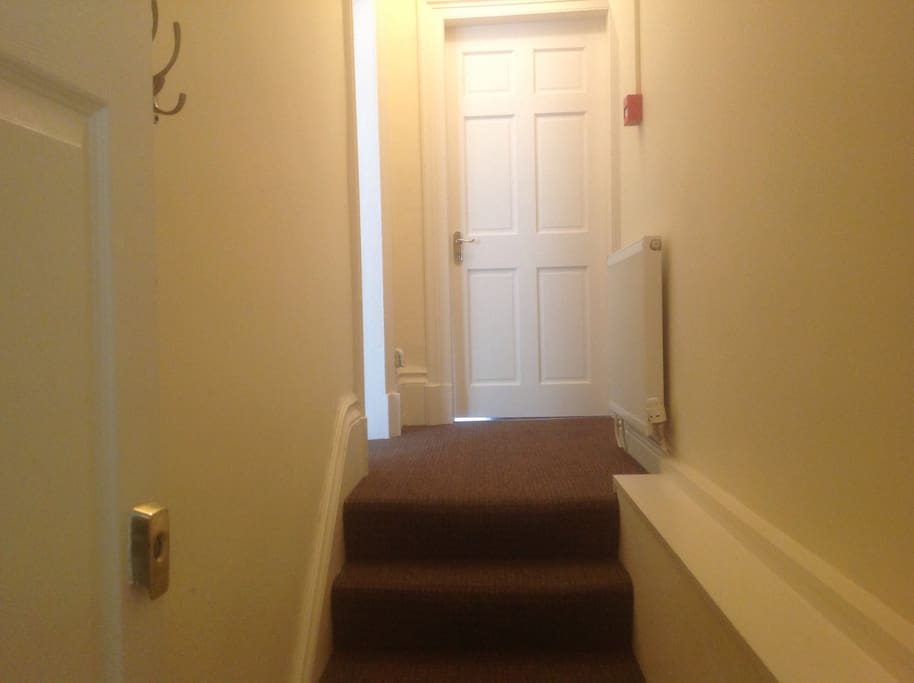 Entrance to apartment with bedroom to the left and open plan lounge and kitchen straight ahead.