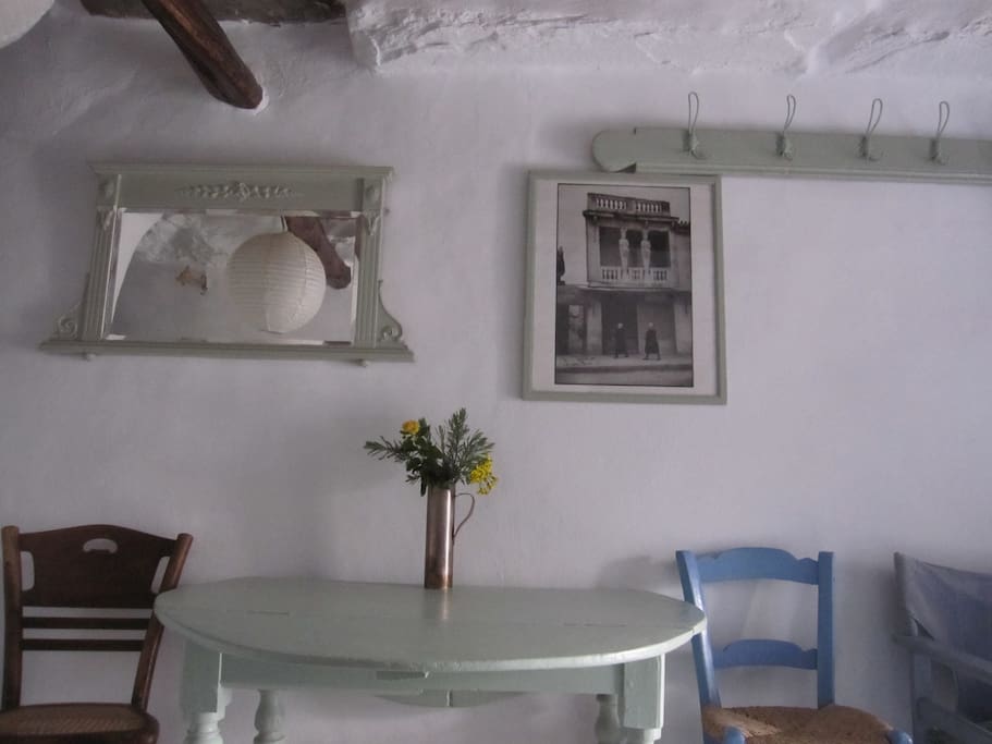 The dining table, with a photo behind by Henri Cartier Bresson of an historic building in Athens, also once painted by his friend, Greece's famous artist Giannis Tsarouchis.