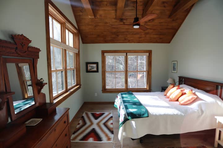 Master Bedroom katika The Big Cabin ina kitanda cha malkia, dari iliyofunikwa na shabiki, kabati kubwa na mtazamo wa kuvutia zaidi wa maporomoko ya maji na mkondo ambao utawahi kuona kila asubuhi unapoamka!