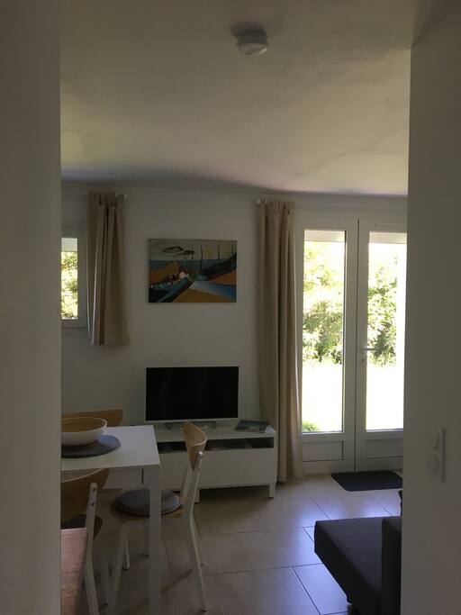 Repas et séjour avec télévision. Accès à la terrasse.