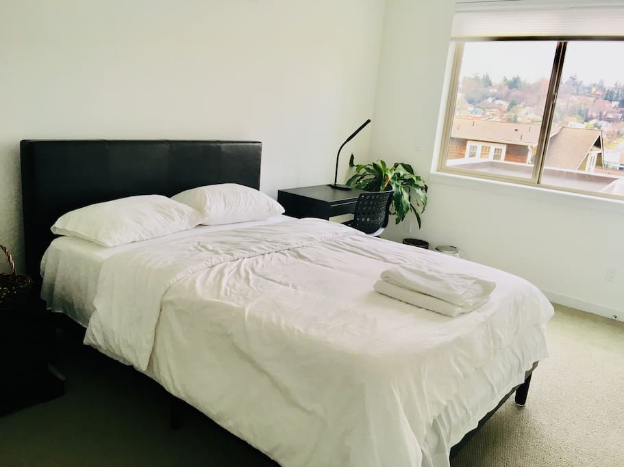 Queen size bed with comfortable mattress and night stand.