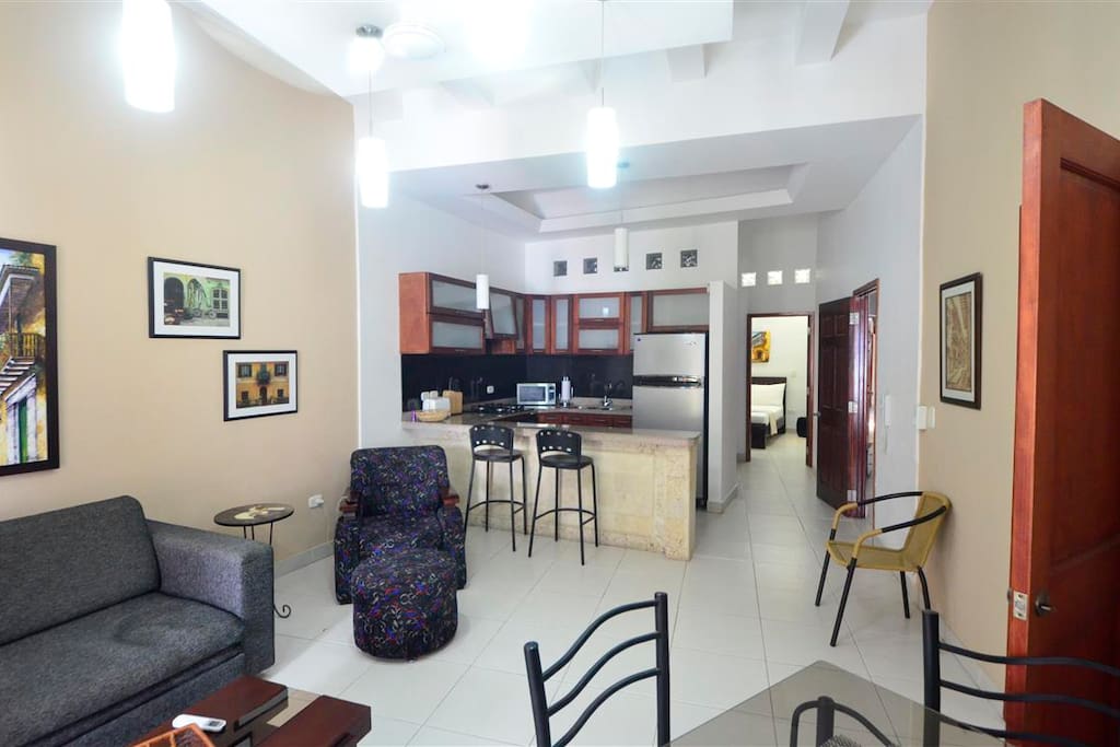 A large Living room with Tv, a bed sofa, a dinning room with AC.