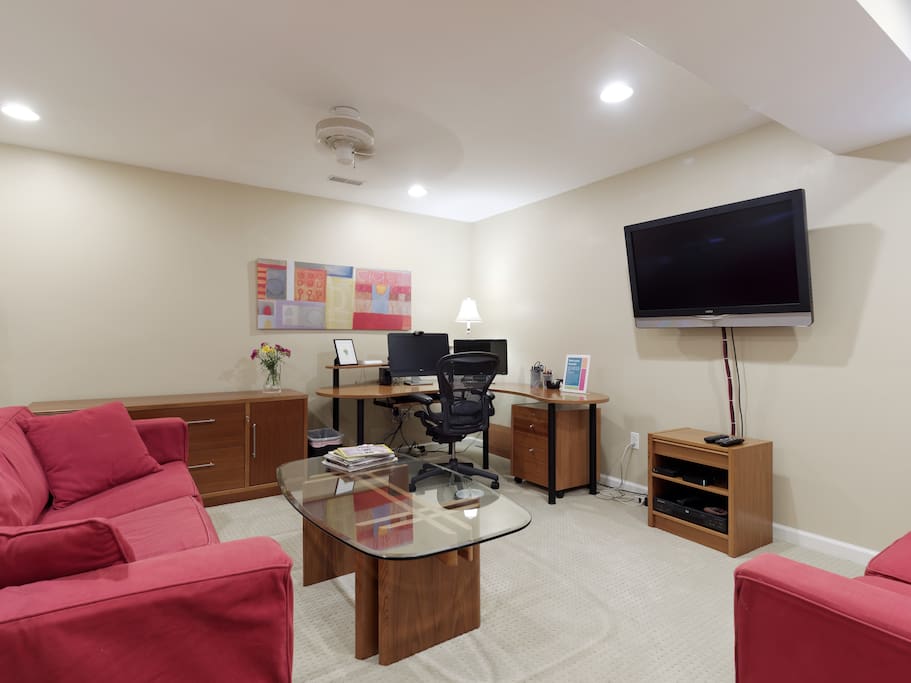 Guest living room with desk, and TV with Xfinity, Roku and DV player. Guests staying a week or longer can use the guest account on the computer.