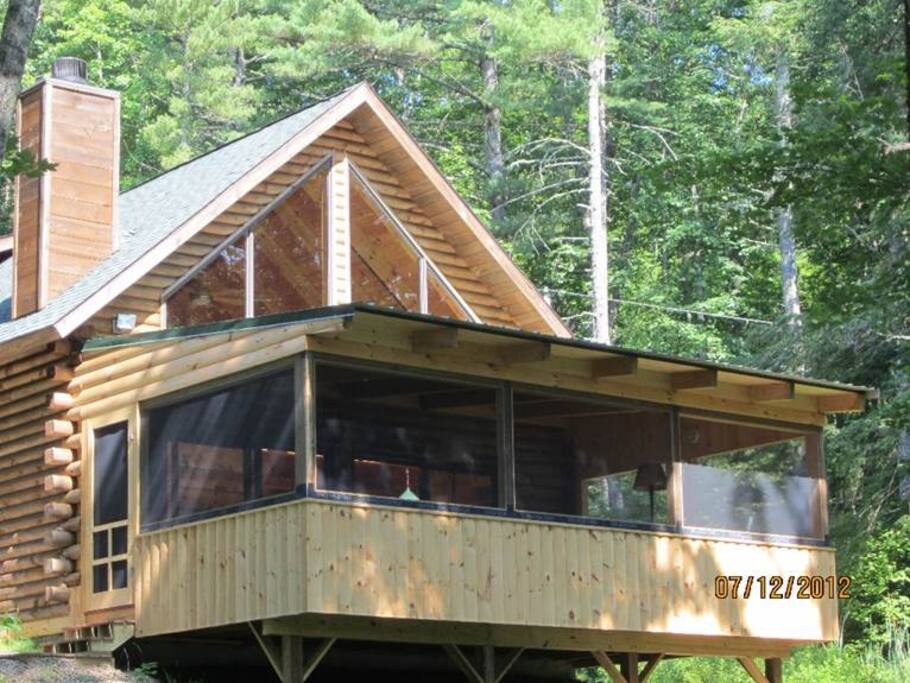 view of house from path coming up from the lake. 16x40 screened in porch on front of house