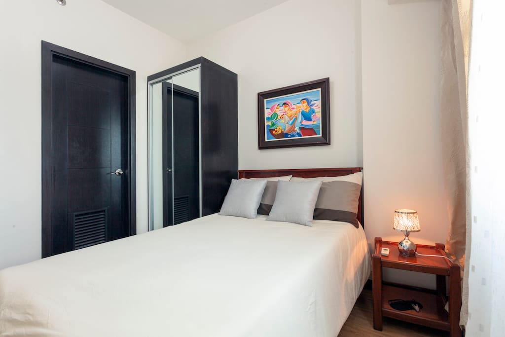 A wardrobe cabinet with mirrored doors and touch-sensitive bedside lamp to add to your convenience