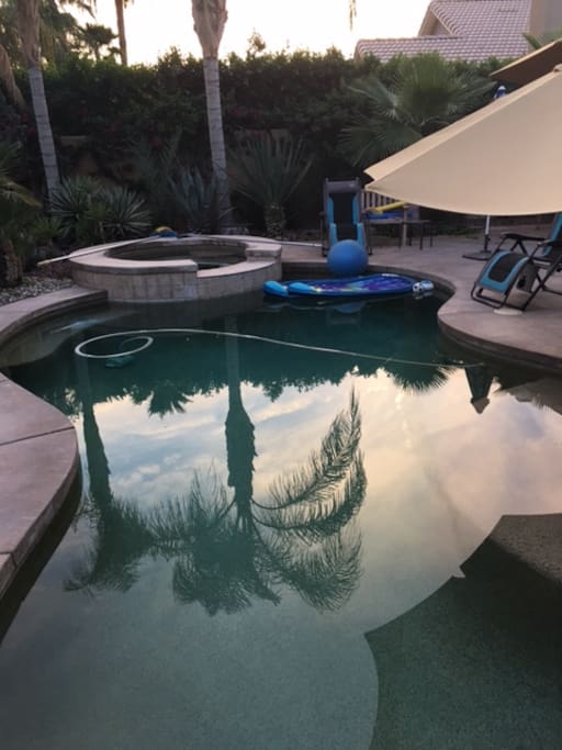 shared pool with pool floats, lounge chairs patio furniture