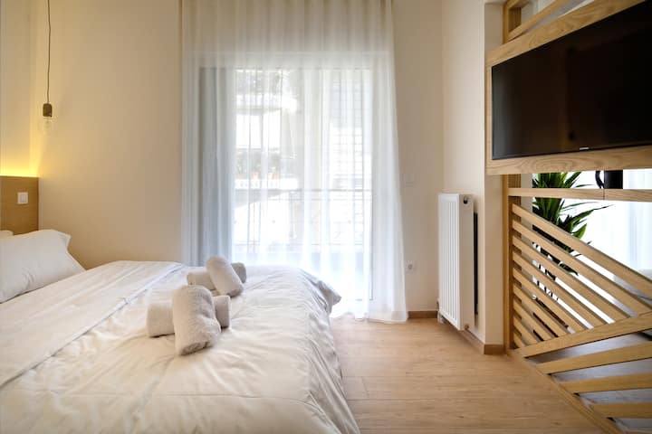 Dormitorio doble con acceso al balcón y TV inteligente plana.