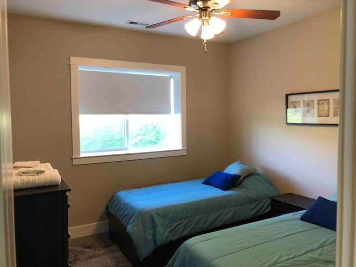 חדר השינה בקומה הראשית עם שתי מיטות זוגיות ארוכות במיוחד.