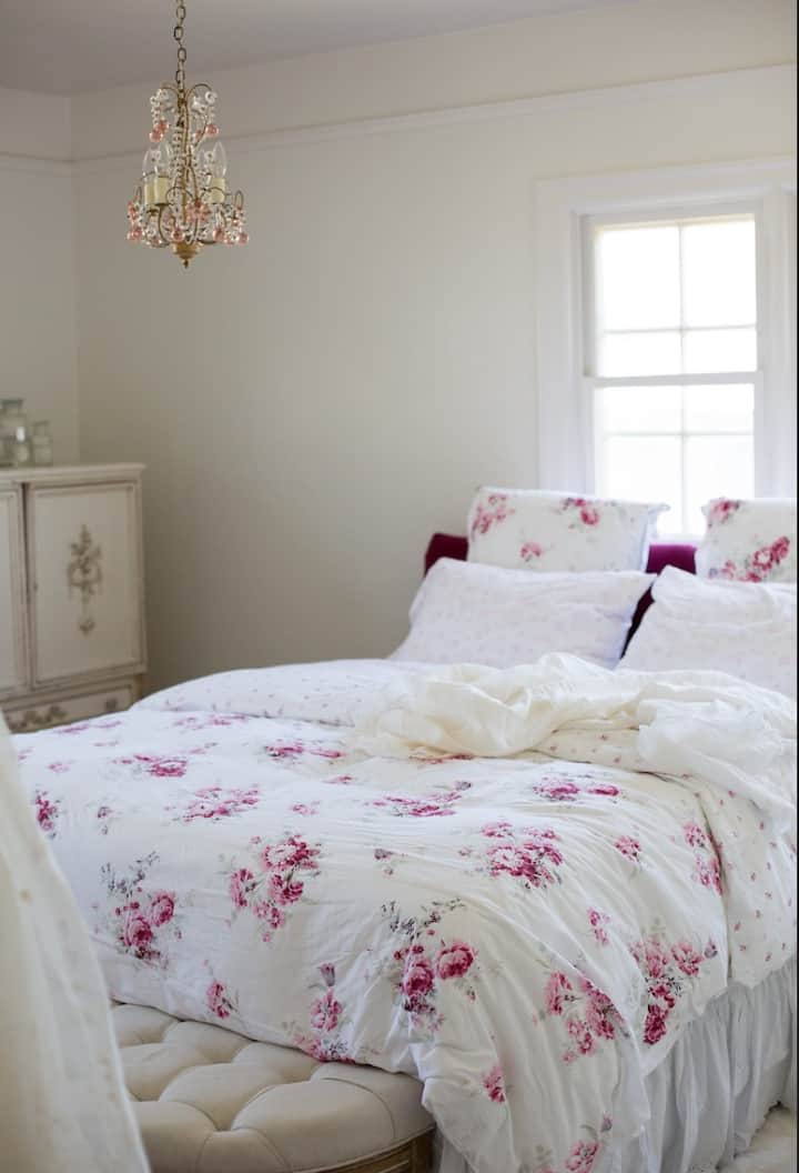 Stanza rosa, con biancheria da letto in piuma e lampadario Rachel Ashwell rosa ~