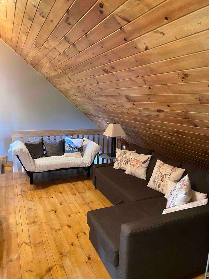 Loft area with smart T.V., queen pull out bed in couch and twin fold down futon.  