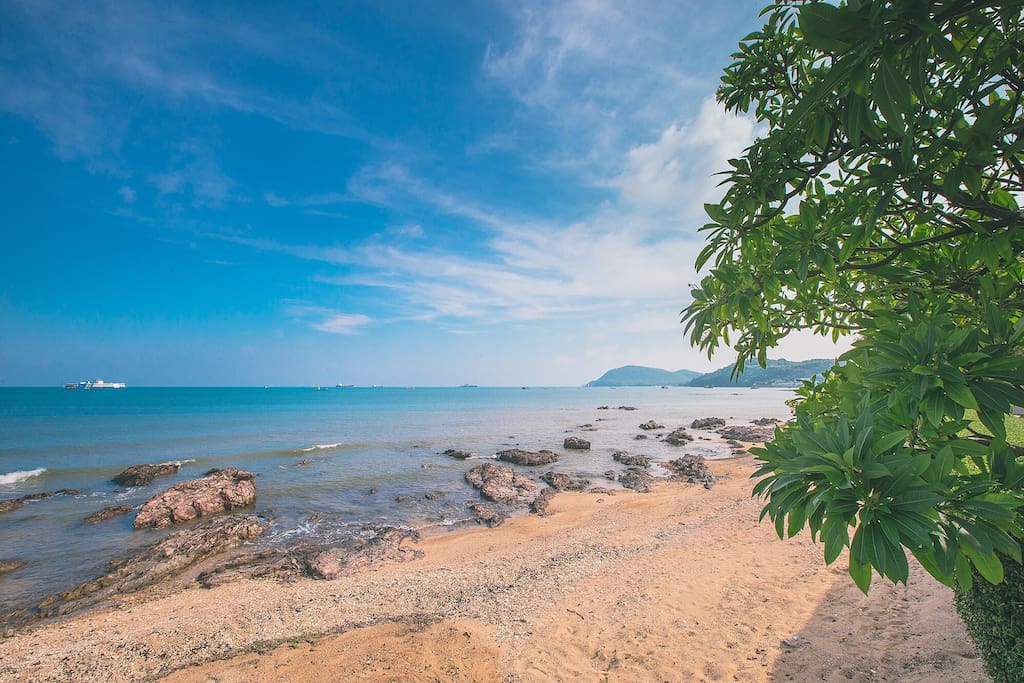 Sand, rocks and clear warm waters stretch along the beach front.