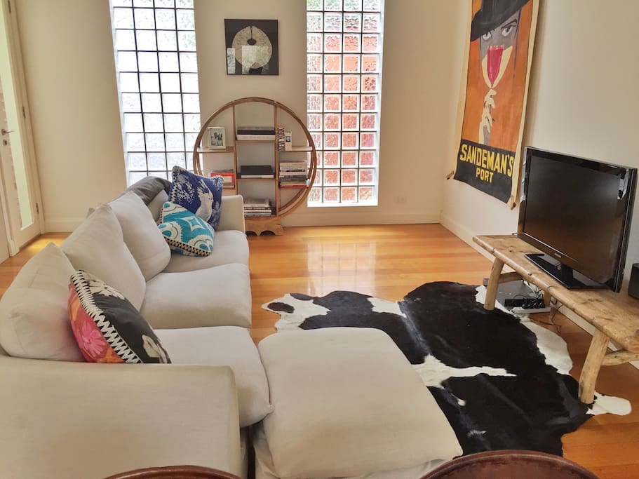 Open plan living area with four seater sofa, TV and DVD player