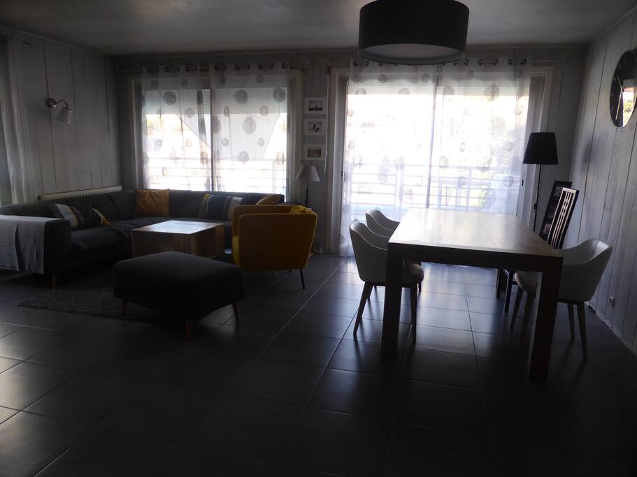 Salon, salle à manger avec 2 baies vitrées donnant sur jardin et la terrasse de la piscine.