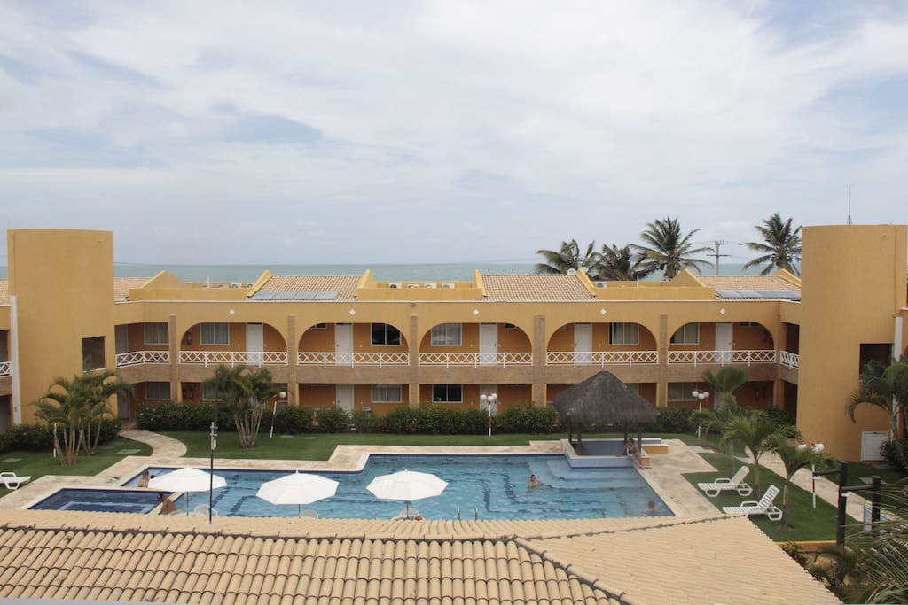 Varanda com vista para o mar e piscina.