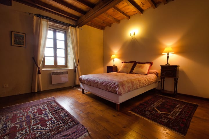 חדר שינה ראשי עם מקלחת צמודה, כיורים כפולים ואמבטיה מלאה. יש גם קיר של ארונות מובנים.