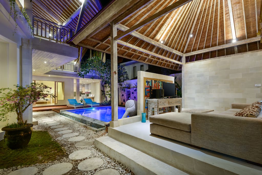 Outdoor lounge and dining area overlooking the pool and garden.