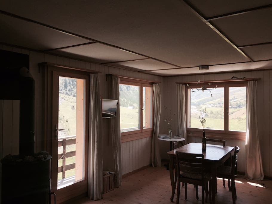 Wohnzimmer mit Esstisch, Sofa und Kamin