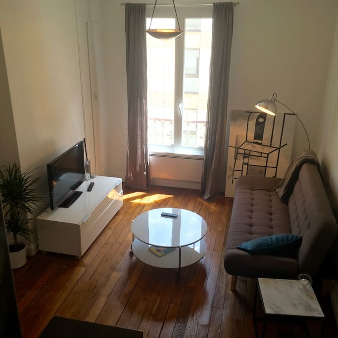 Living room with moulding and wooden floor. Equiped of a large TV, wifi, a sofa bed, heater.