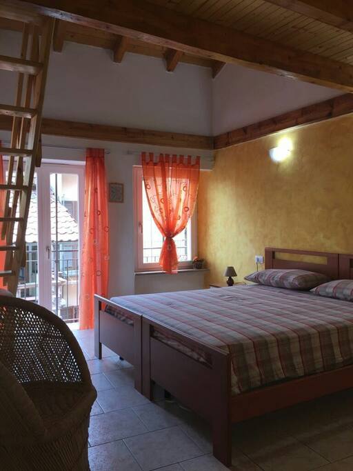 camera da letto, balcone e scala che porta al soppalco