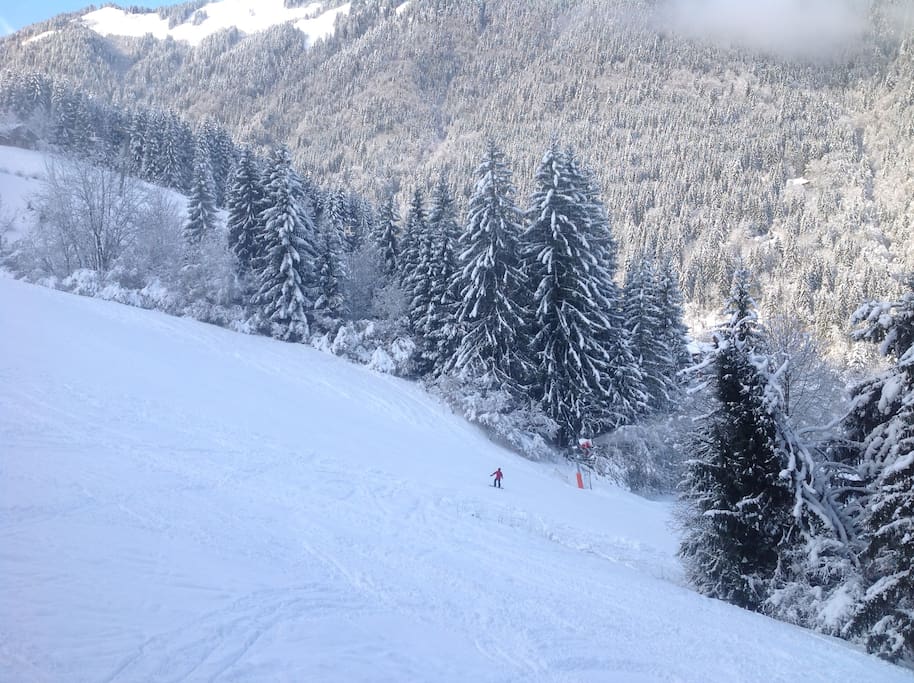 View from balcony of red ski run back to bubble lift.