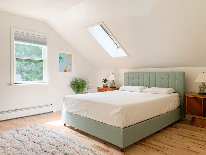 ห้องนอนหลักอยู่ชั้น 1 พร้อมเตียงควีนไซส์