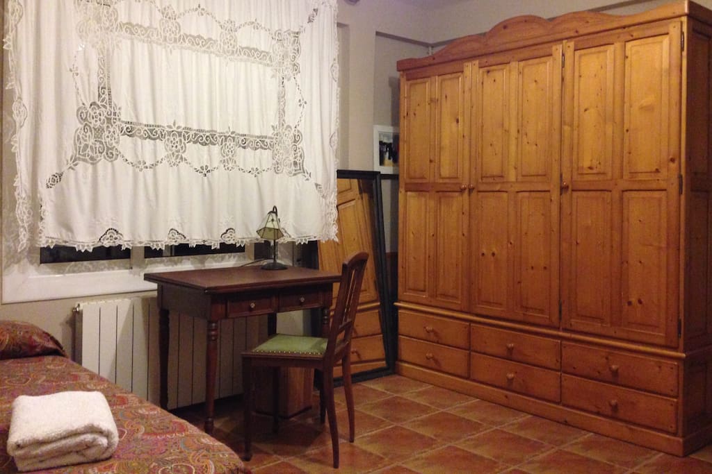 Dormitorio con mesita y silla