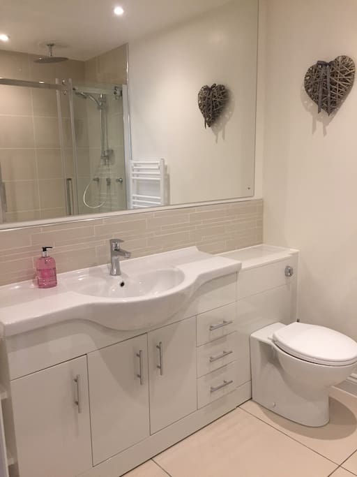 Bathroom sink and toilet with shaver socket, mirror and storage. Large heated mirror when bathroom lights go on.