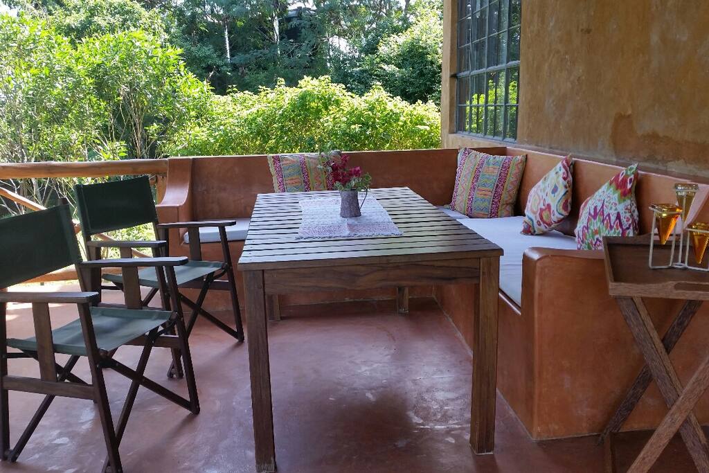 Main entrance verandah and lounge area facing the sea and surrounded by a lush garden.