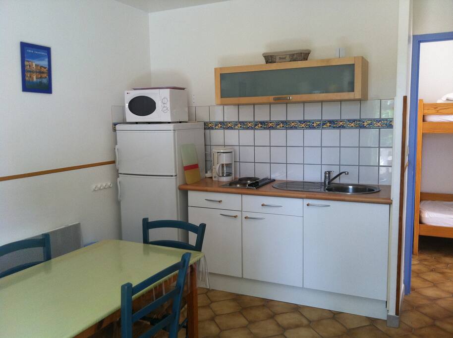 coin cuisine avec 2 feux électriques, réfrigérateur-congélateur, micro-ondes, cafetière. Accès vers sas d'entrée avec lits superposés.