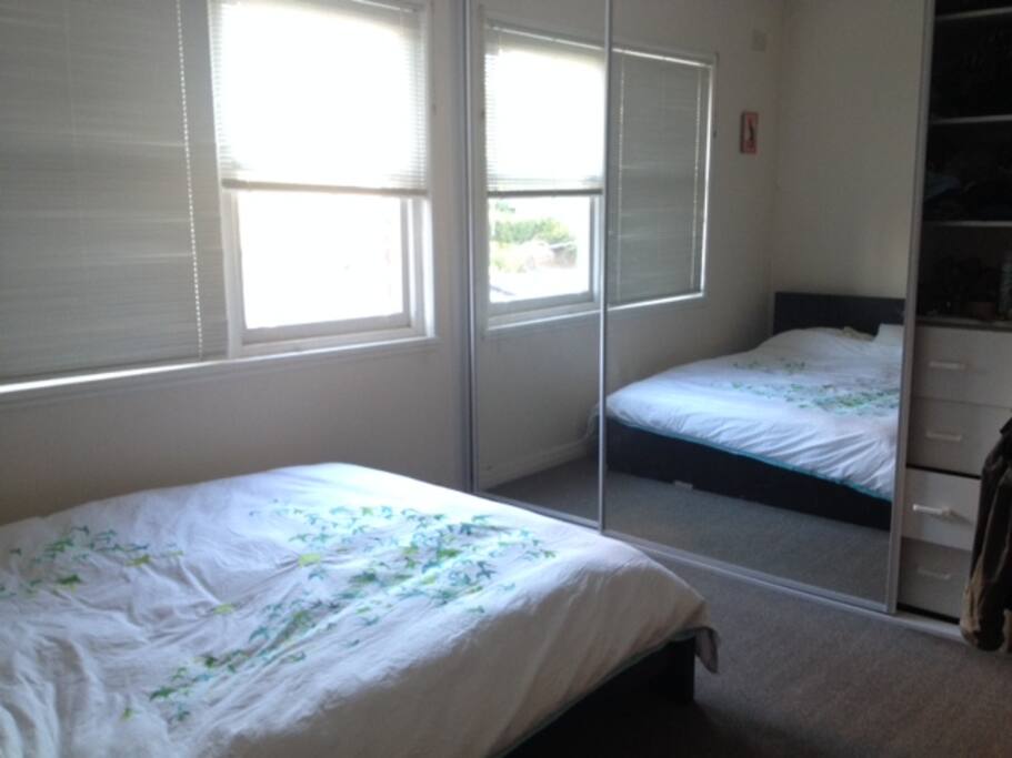 Comfortable and spacious master bedroom with built-in wardrobe, full-length mirror and desk